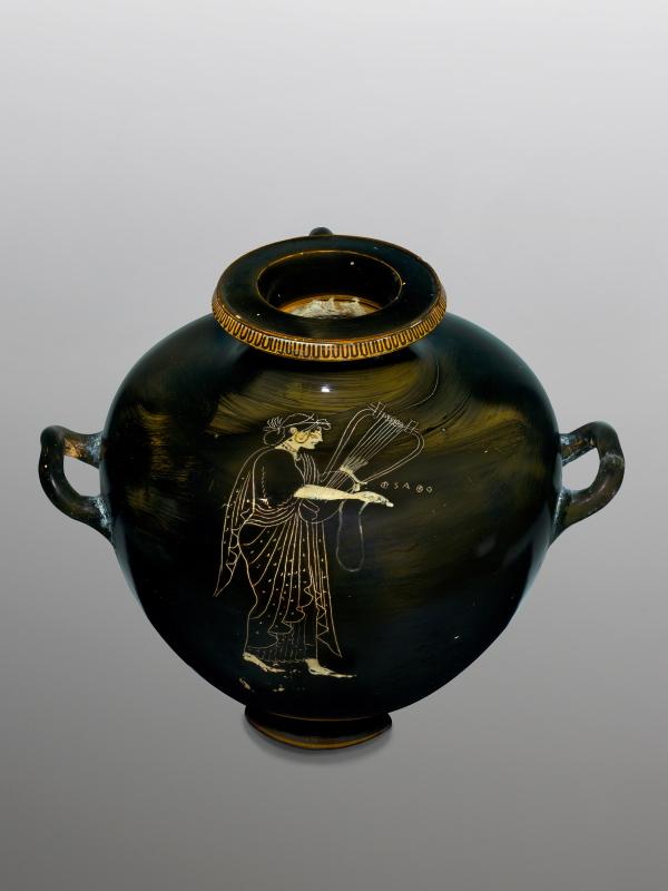 photo of a ancient pot that has a painting of a woman holding a harp.