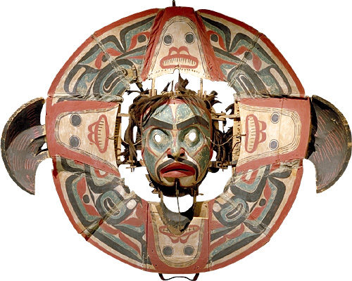 Transformation Mask with human face in the center of a circle surrounded by four more faces 90 degrees apart.