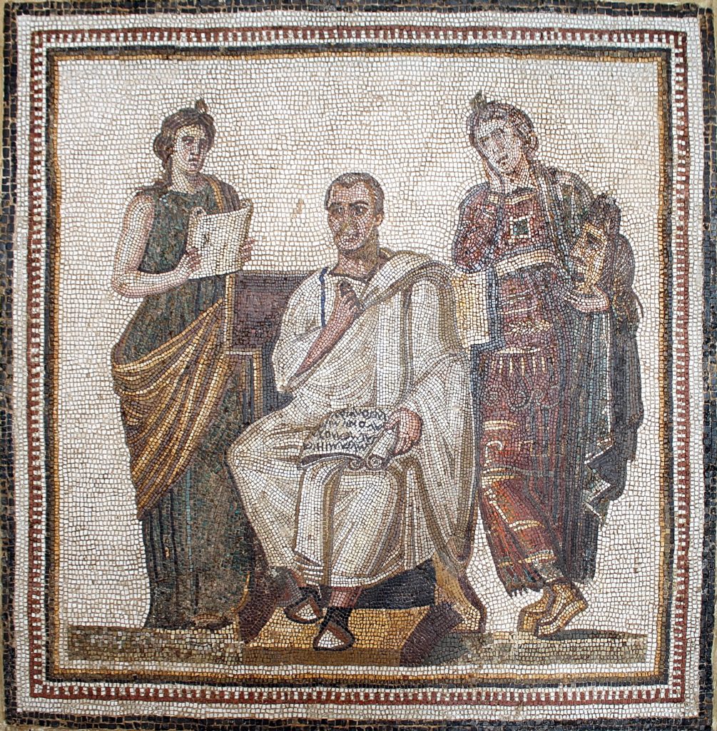 a mosaic of a man dressed in a white robe in a sitting position with scroll in left hand surrounded by one woman standing on the left and one standing on the right dressed in dark robes.