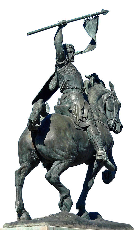 Statue of a warrior on a horse in motion raising a spear flag.