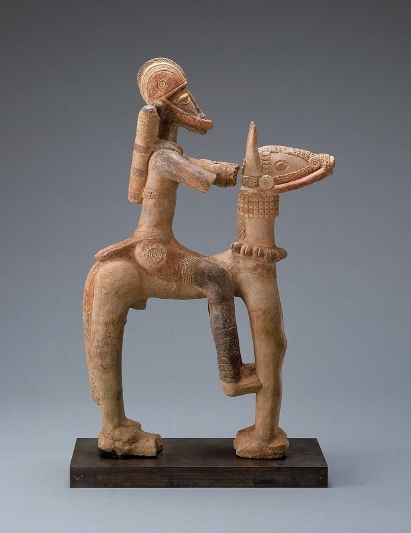 a terracotta warrior riding a horse on a pedestal.