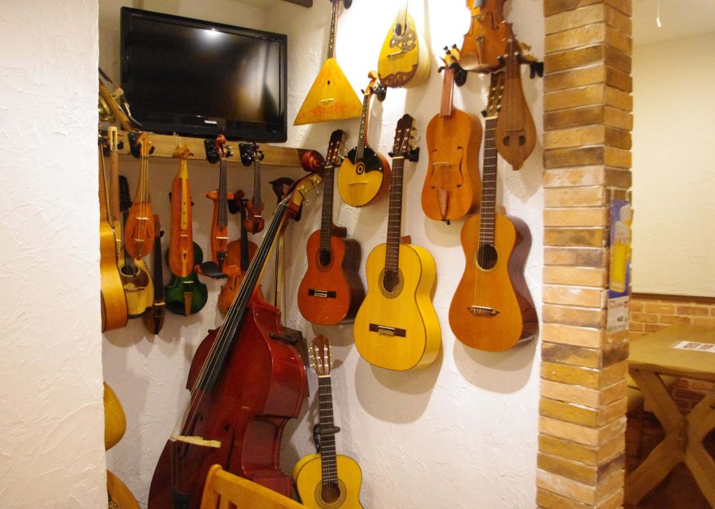 Photo of different string instruments hanging on a wall