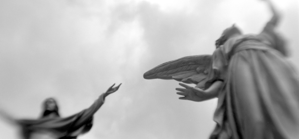 Black and white photo of a statue of Jesus and an angel.