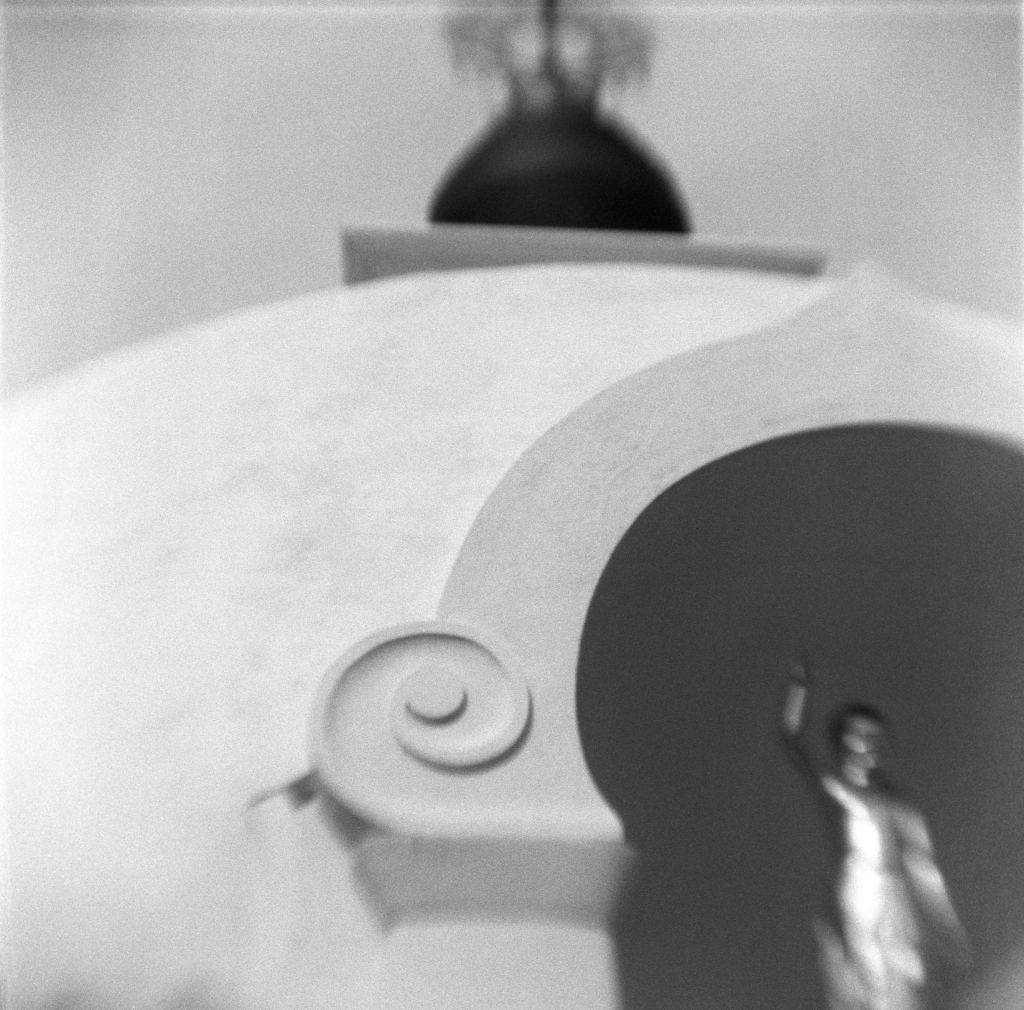 Black and white cropped photo of a white dome peace pagoda covering a gold statue.