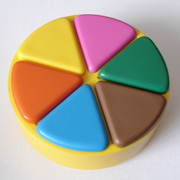Photo of yellow Trivial Pursuit playing piece with orange, blue, brown, green, pink, and yellow wedges