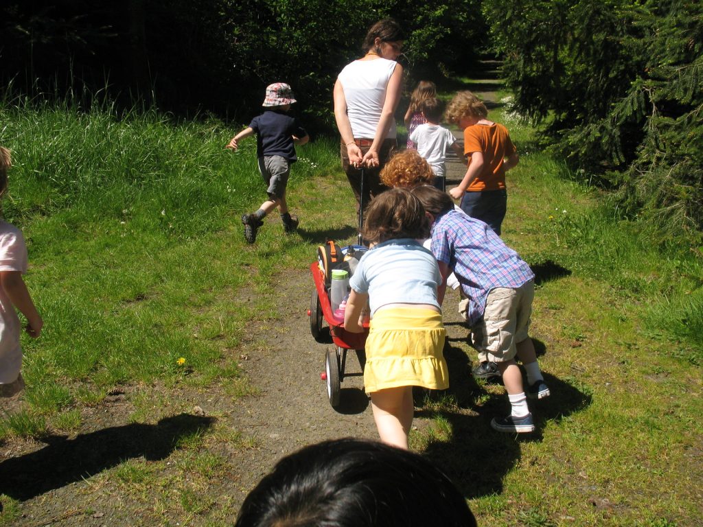 Children helping to push a red wagon