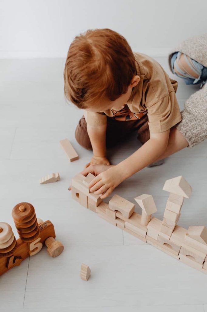 Photo of a young boy playing with wooden blocks
