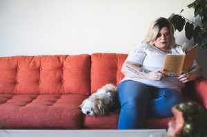 image of woman sitting on couch with dog