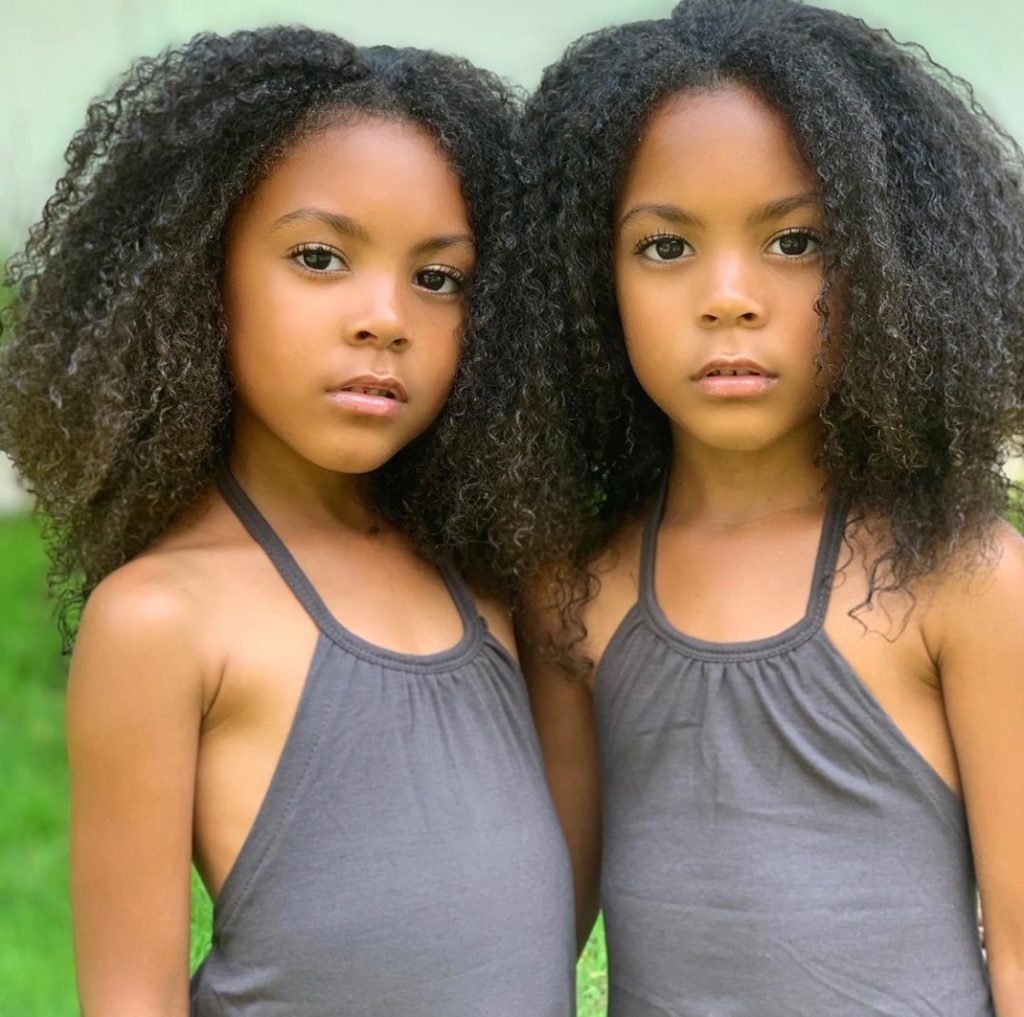 Image of twin girls stand side by side.