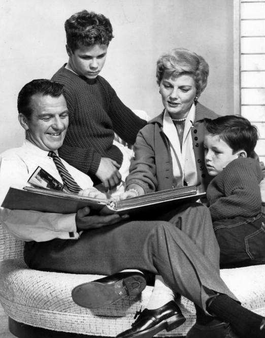 Characters (father, 2 sons, mother) from the television show Leave it to Beaver sit around a family photo album.