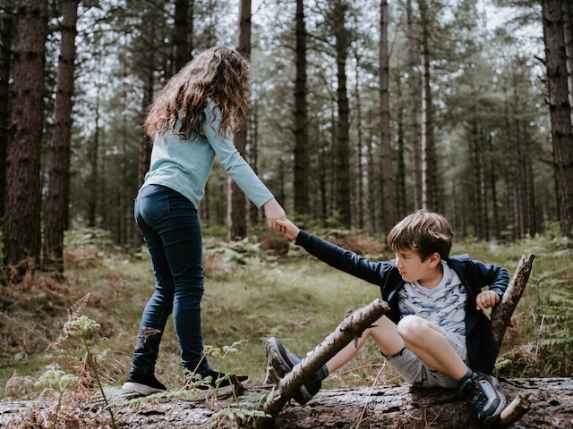 Image of young girl and boy playing in the woods