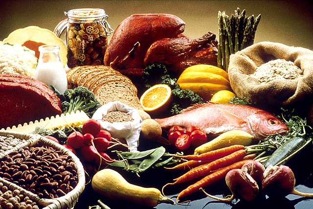 This image shows a wide variety of whole foods, including fish, poultry, vegetables such as carrots, radishes, beats, broccoli, cauliflower, asparagus, green beans, and various leafy greens, as well as nuts, milk, fruit, pasta, bread, and other grains.