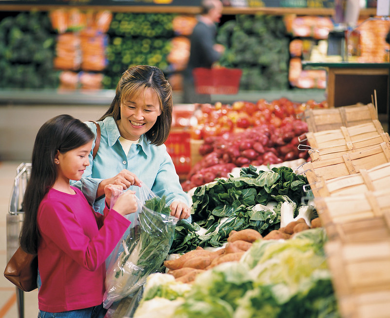 Photo of mother produce shopping with daughter.