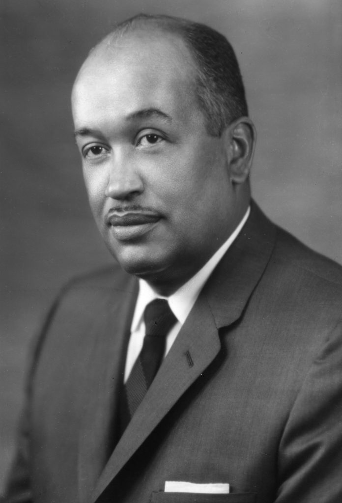 Black and white photo of an African American man dressed in a suit and tie.
