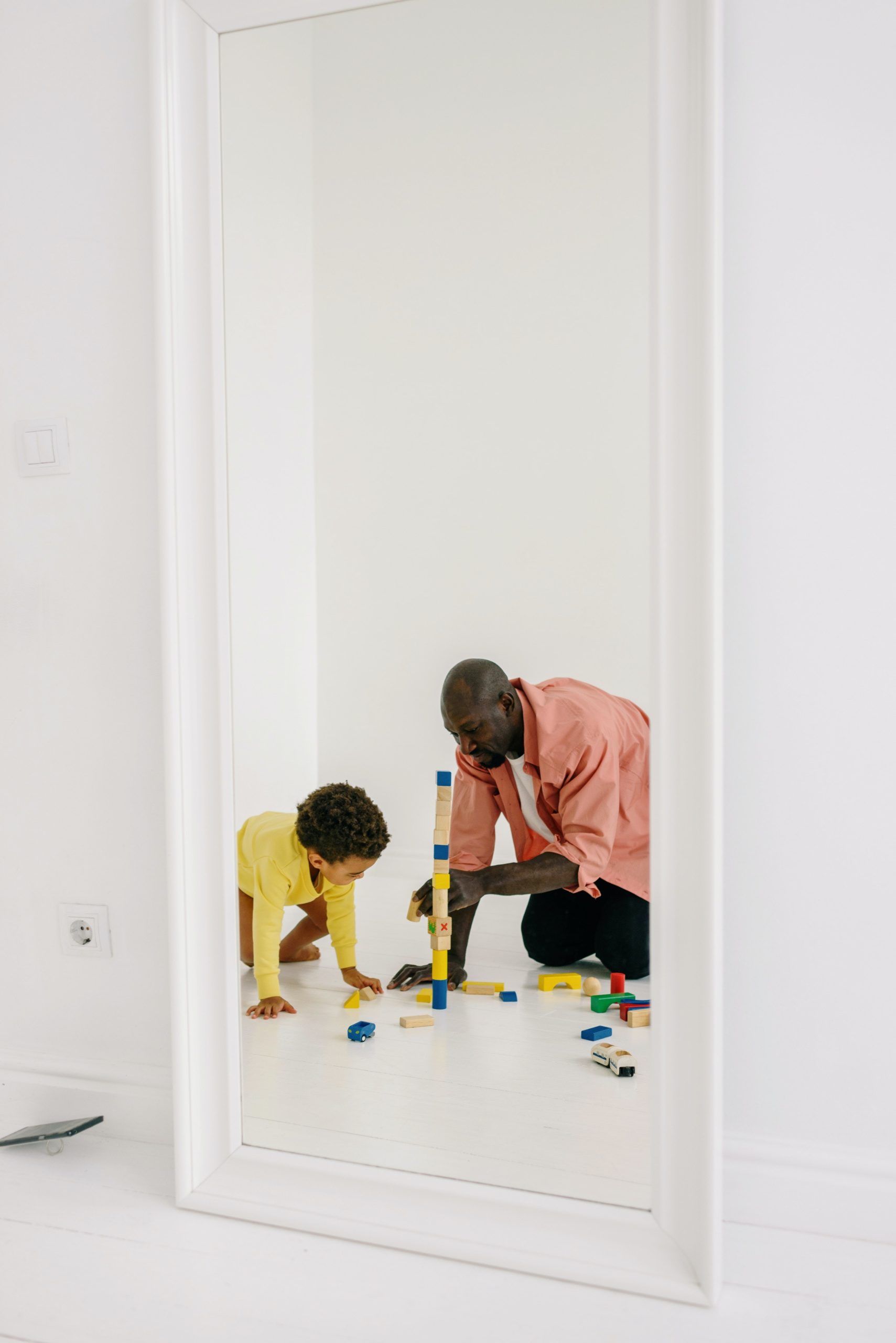 image of mirror reflection of father and son at play