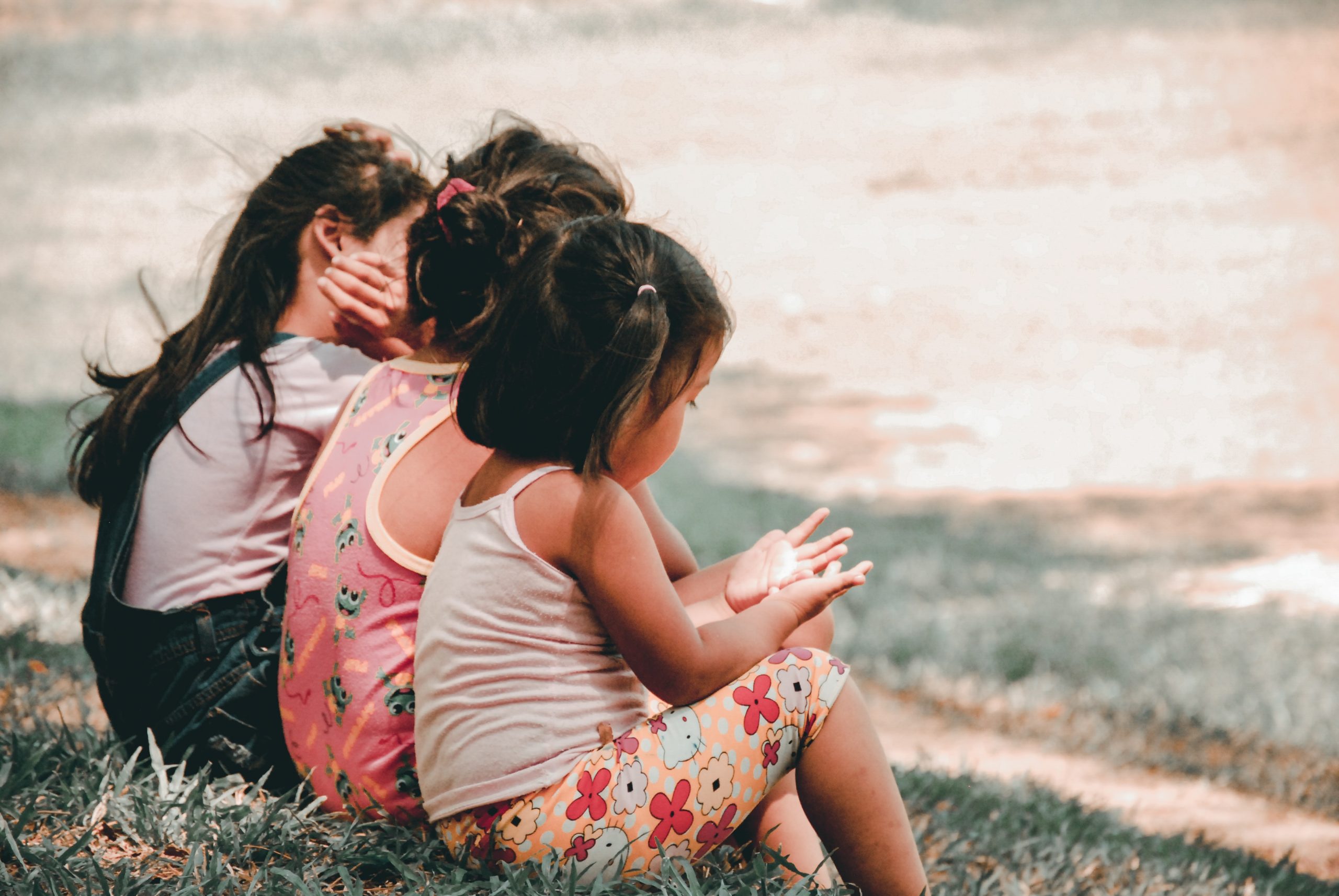 Image of three young girls sitting on the grass