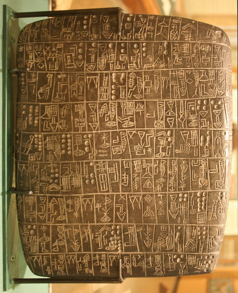 Stone with carving of characters.