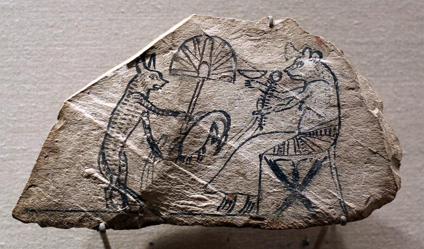 drawing on a rock depicting a cat waiting on a mouse with a big fan