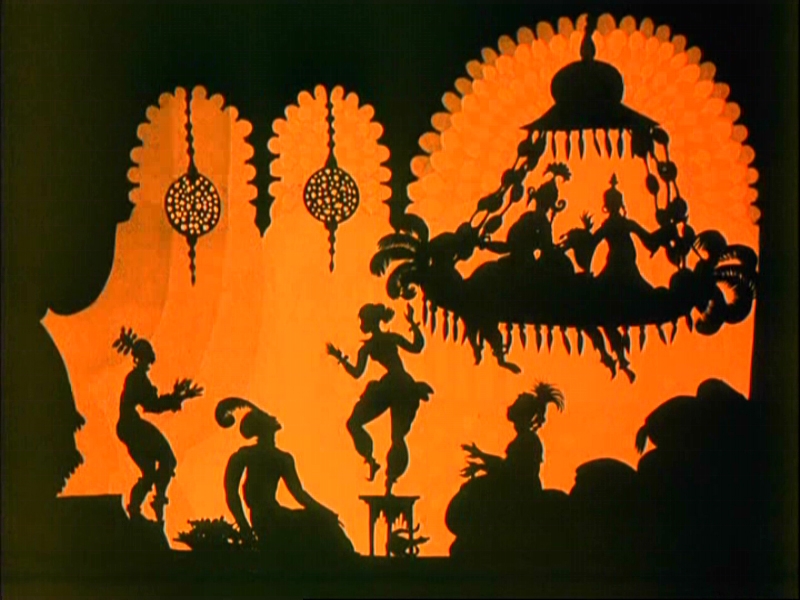 The figures are in black and the backdrop / setting is in orange. Clothing includes turban, long features projecting from the heads