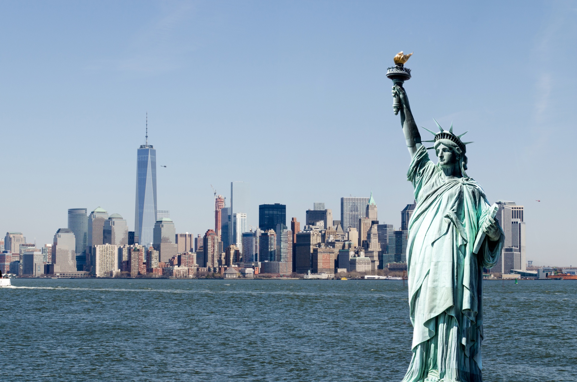 Photo of Statue of Liberty with view of the water and NYC in the background