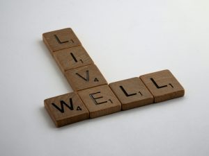 Photo of scrabble pieces spelling out the words "LIVE WELL".